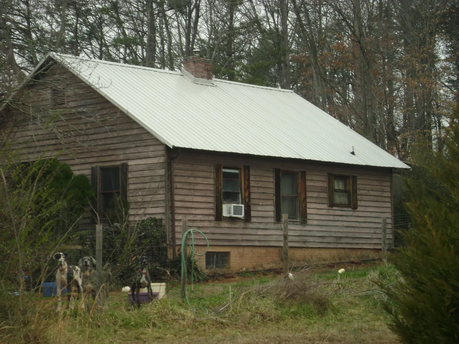 White metal roof on an old wood sided farmhouse, from a Metal Roof Installation job in Whitesville
